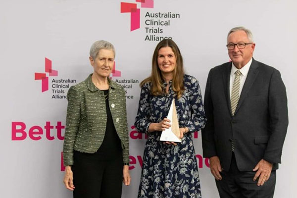 Prof Anne Kelso and The Hon Brad Hazzard MP present the ACTA Trial of the Year Award to Dr Lisa Higgins, Monash University, on behalf of the REMAP-CAP team.