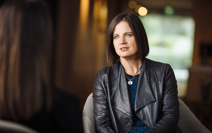 woman in chair talking to person in front of her