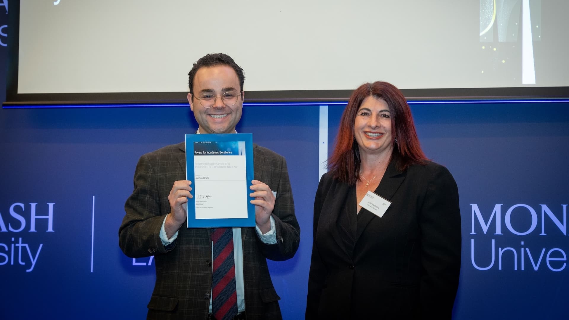 Joshua Bruni accepts her prize from Julie Petinella of Thomson Reuters