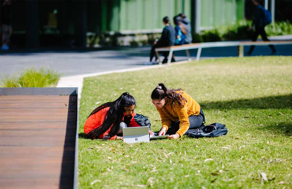Monash students collaborating outdoors at the Clayton campus