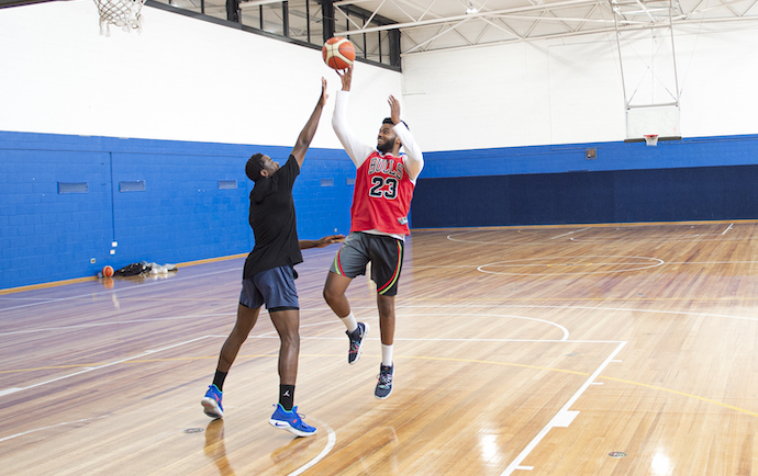 two people playing basketball on a court