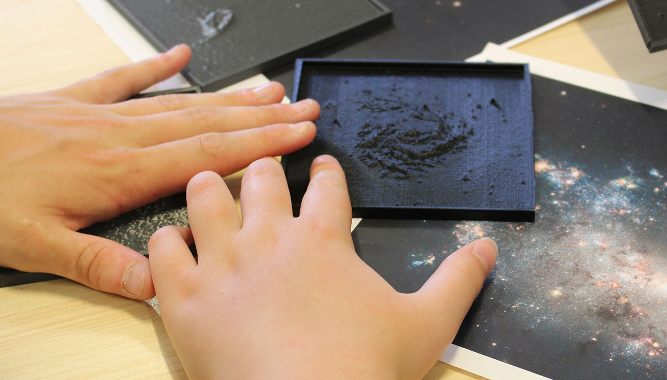 Nicholas Bonne helping student with model of galaxy