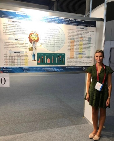 Melis standing with academic poster at conference