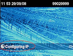 A desk phone screen showing a loading icon and the words ‘Configuring IP’