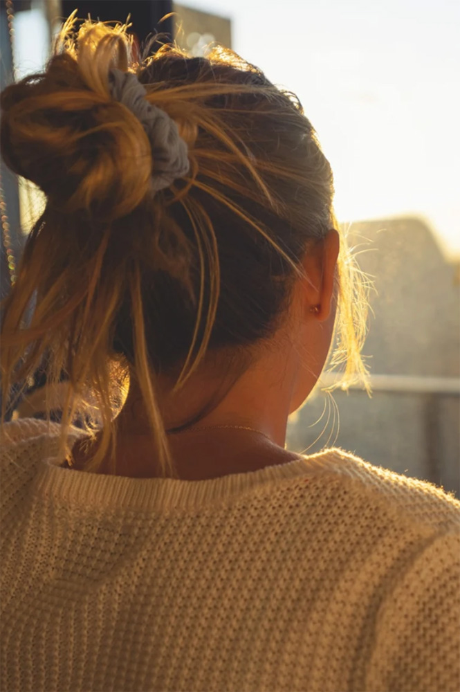 Photo of young woman gazing at sunset