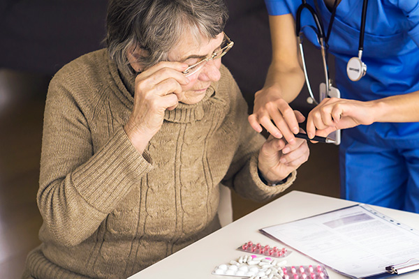 nurse explaining medications to older person