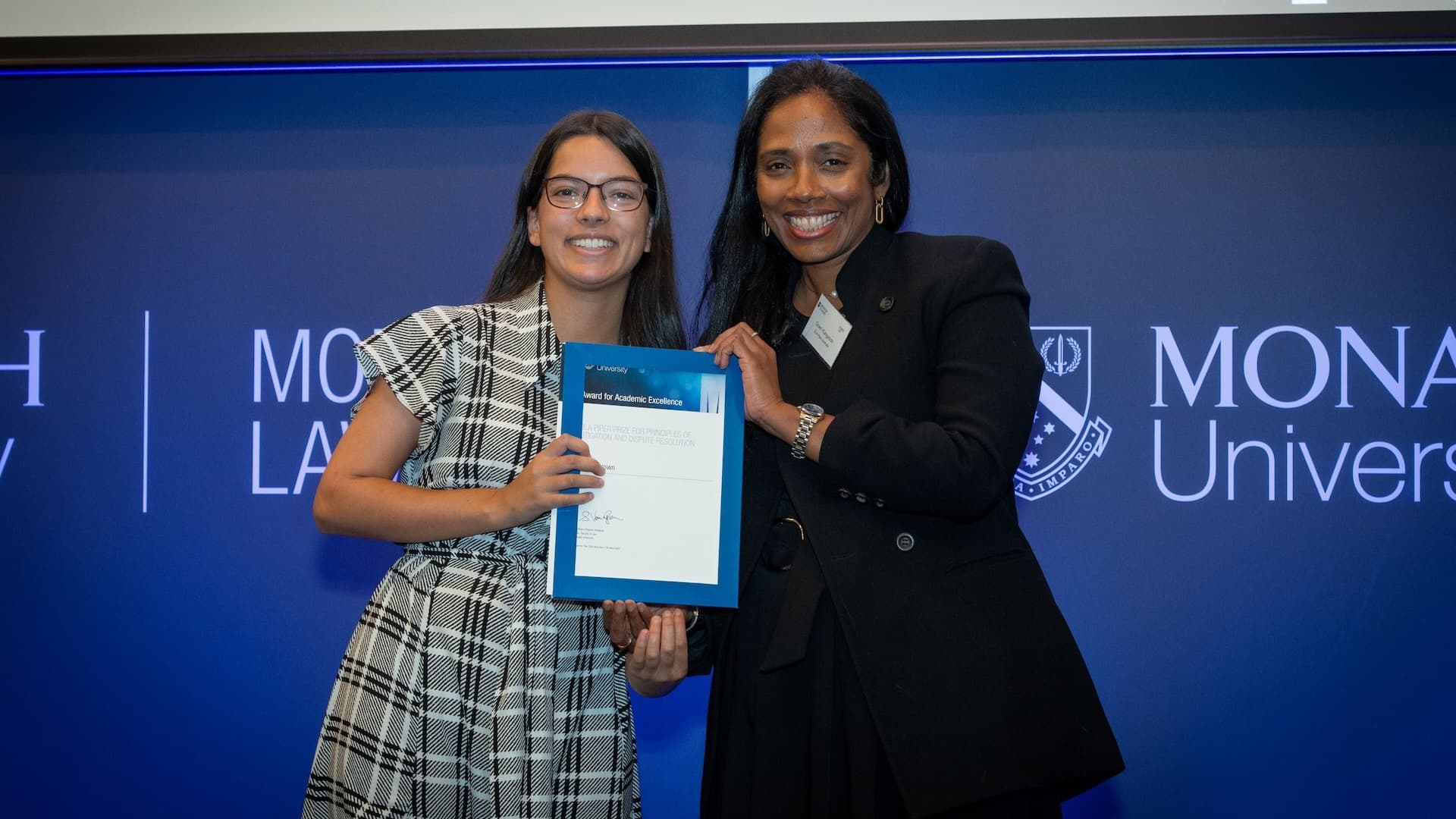 Elishia Brown accepts her prize from Gowri Kangeson of DLA Piper.