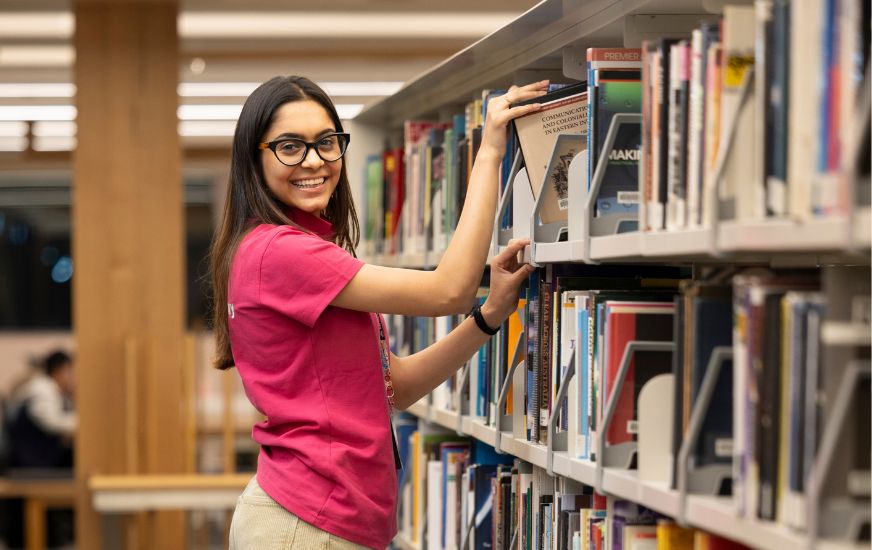 Librarian getting books from top shelf