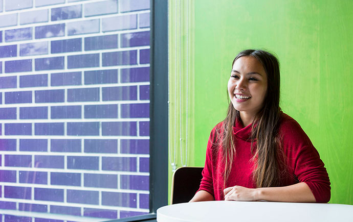 Female student laughing at table