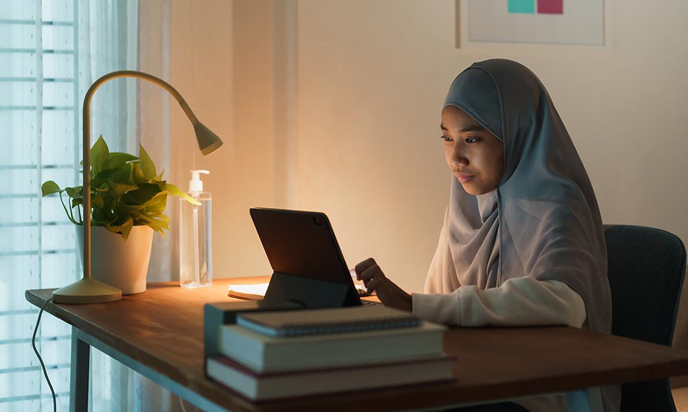 A Brunei student working on a laptop