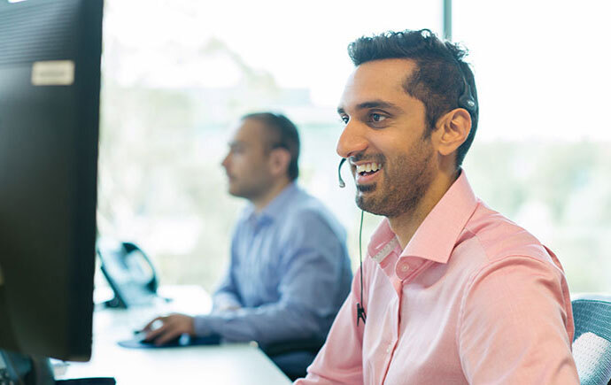 Man with headset sitting in front of computer