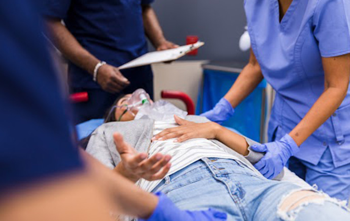 Medical experts attend to a woman on a stretcher in a hospital.