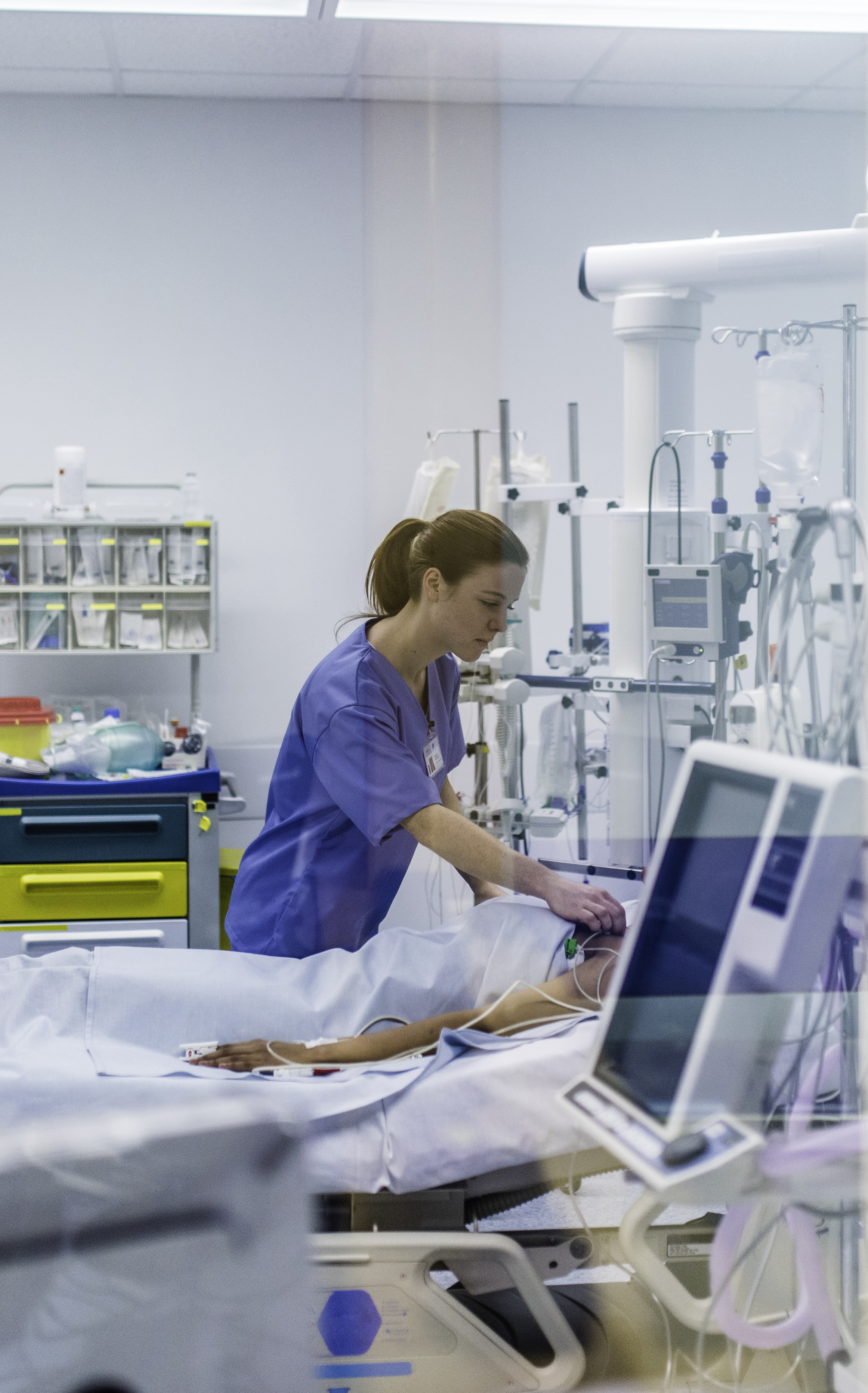 nurse attends to patient in an ICU ward