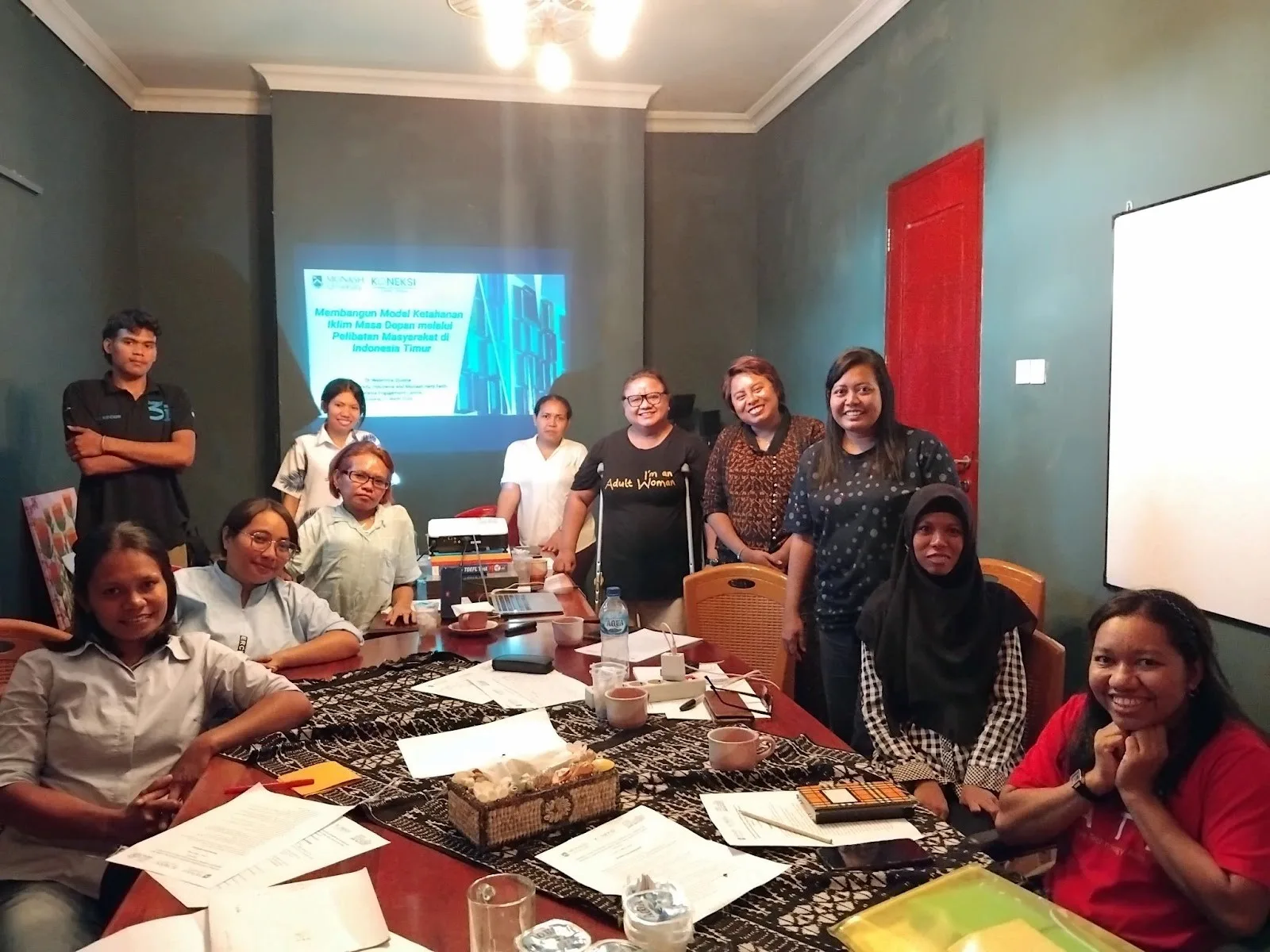 This photo captures all members of GARAMIN posing after the "What, Why, and How to Conduct Research" workshop. Starting from the right corner, Elmy sits in a wheelchair, with Dewi seated next to her. Standing beside Dewi is Berti, followed by Cece.
