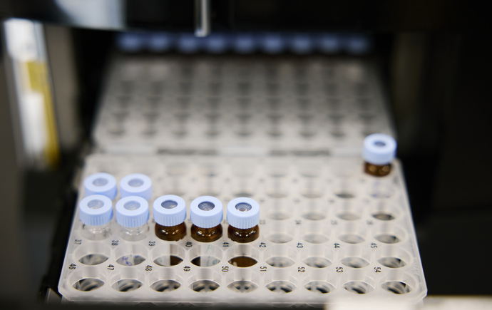 Sample vials arranged in an automated analytical instrument for pharmaceutical testing and characterisation.