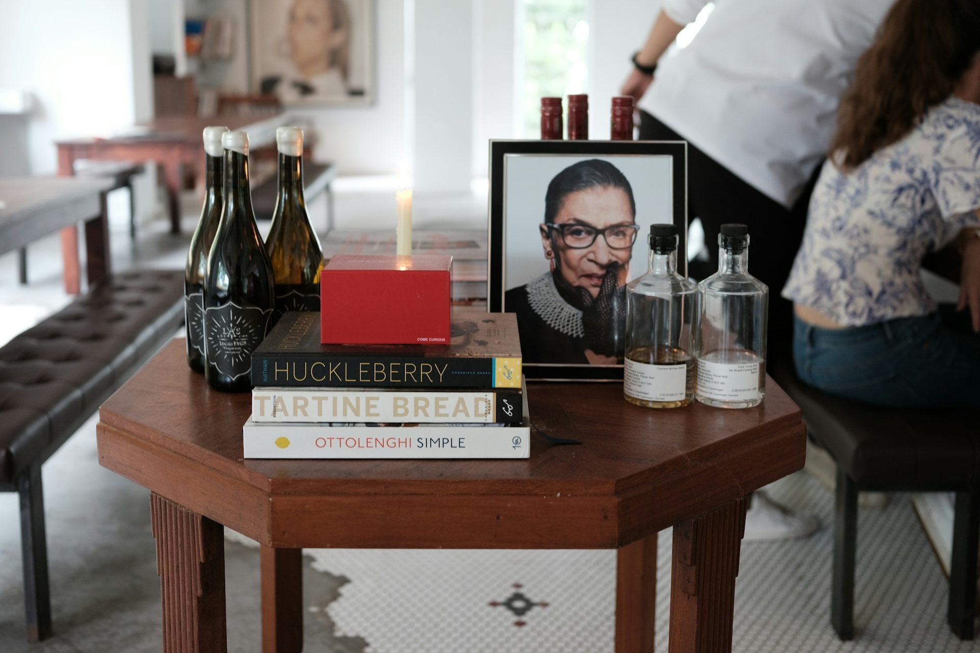 A cafe table featuring a photo of Ruth Bader Ginsburg next to a candle, evoking a sense of remembrance.