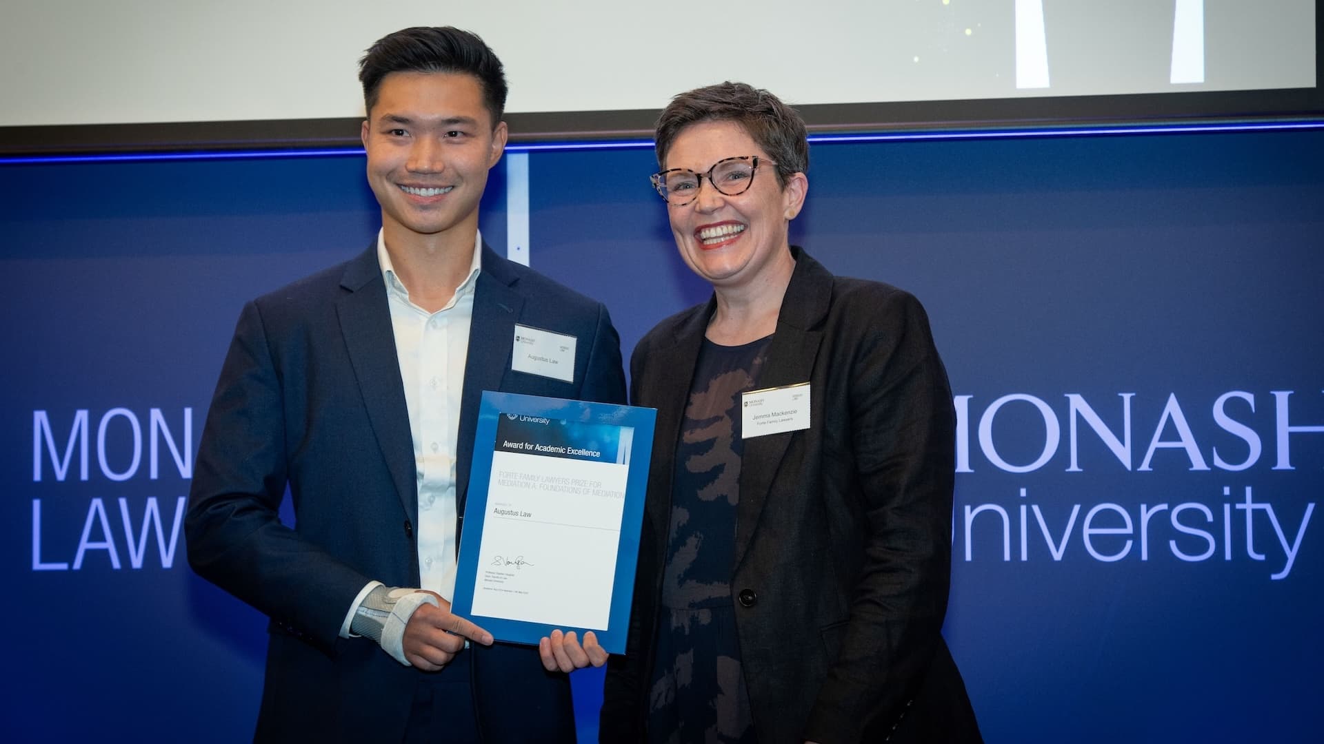 Augustus Law accepts his prize from Jemma Mackenzie of Forte Family Lawyers.