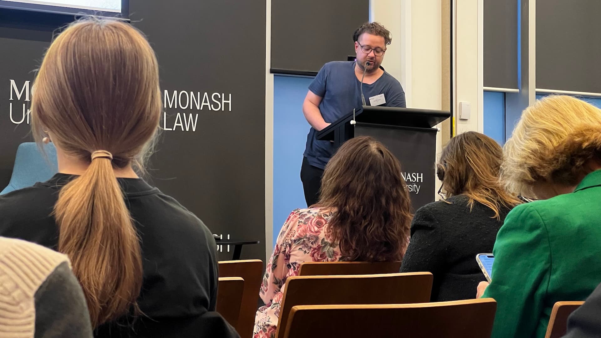 Professor Nic Suzor presenting at a lectern