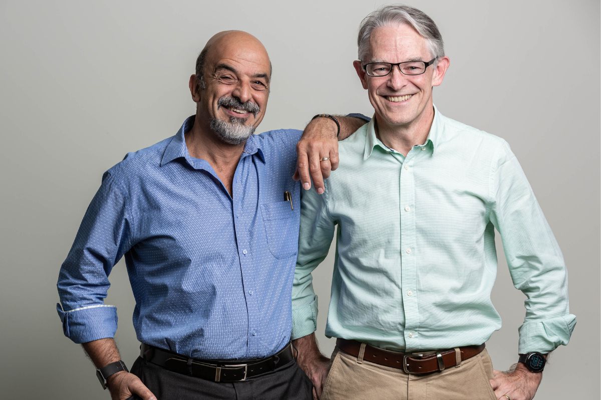 Professor John Christodoulou rest his arm on Professor David Thorburn's shoulder