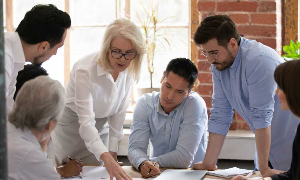 Woman leader coach teach young workers explain paperwork
