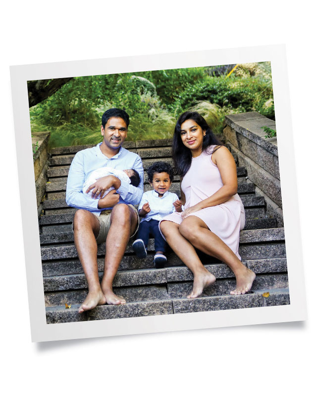 Dr Hemant Chaurasia and Dr Dilani Kahawala sitting on outside steps with their child