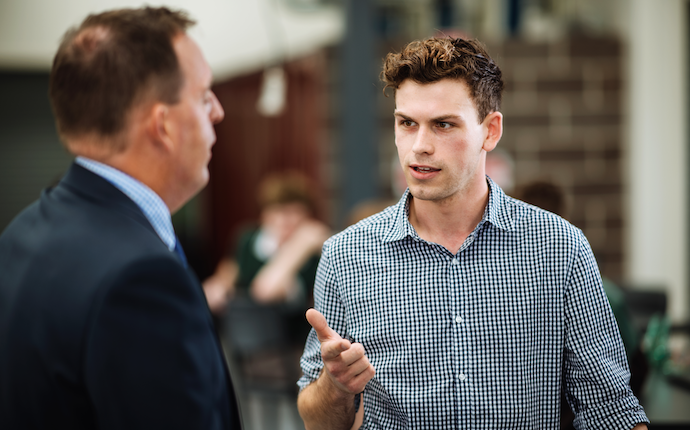 Monash student speaking to researcher one on one in lecture theatre