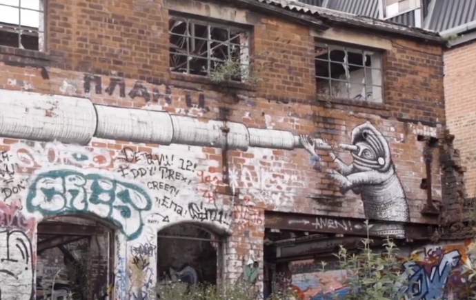 Brick wall of an abandoned building that is covered in graffiti 