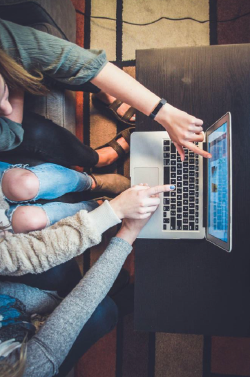 image of people pointing at laptop