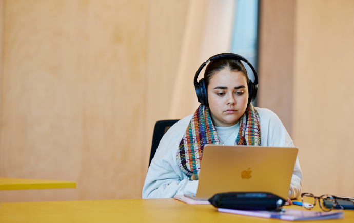 Student with headphones on laptop