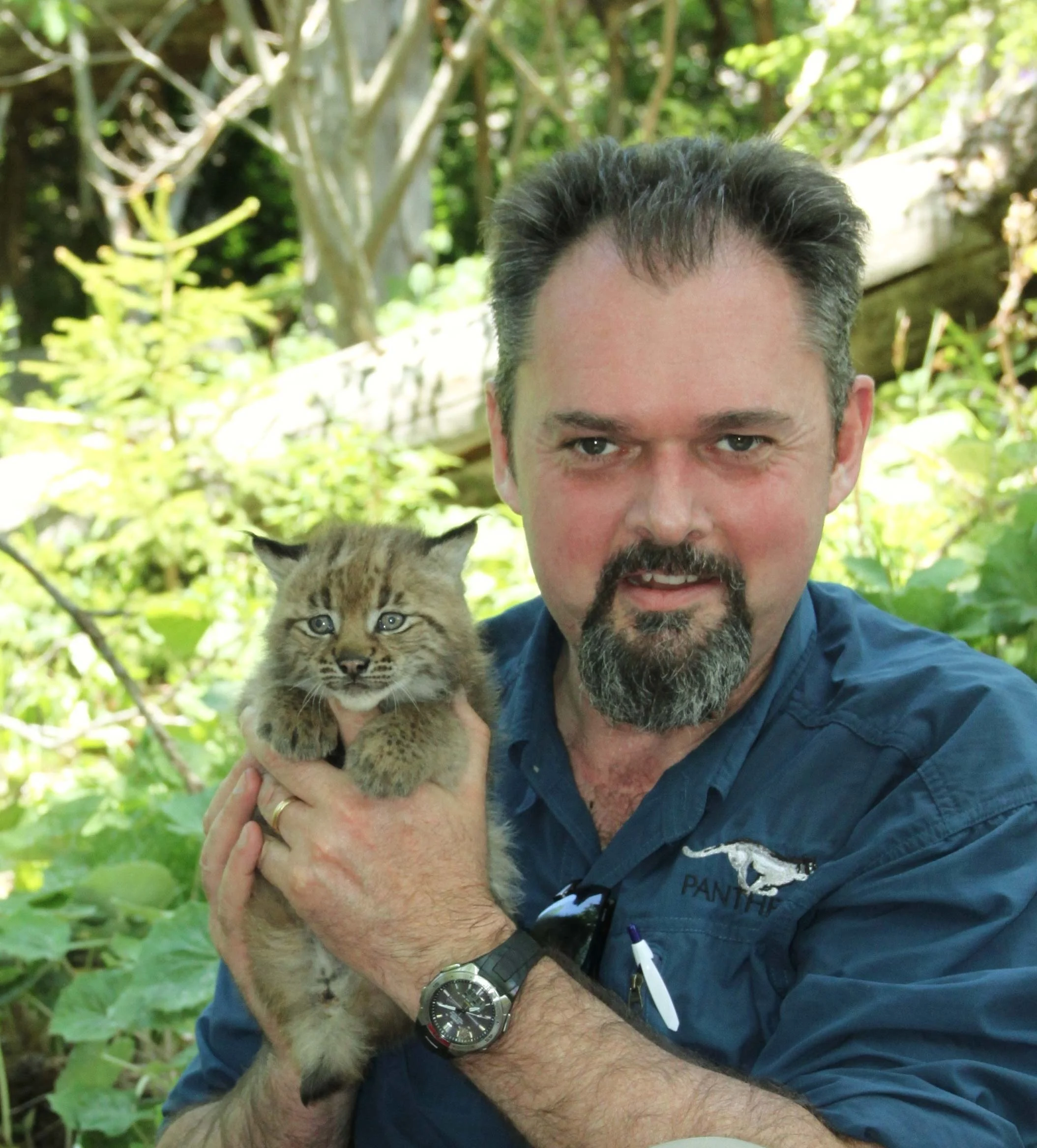 Luke Hunter holding Lynx kitten while smiling
