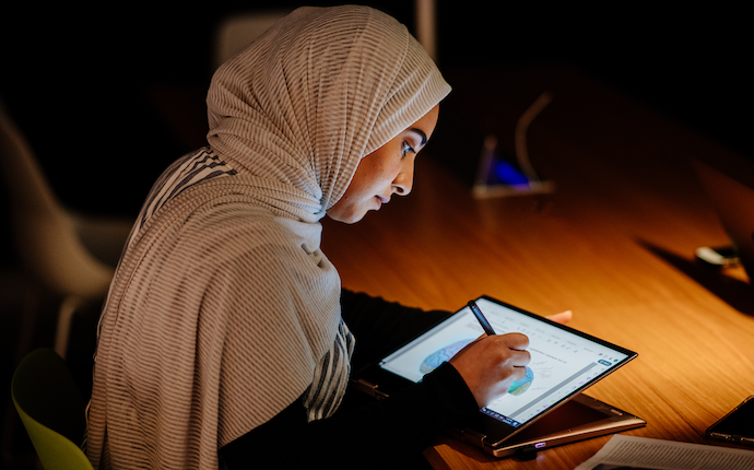 Monash student studying on ipad in library