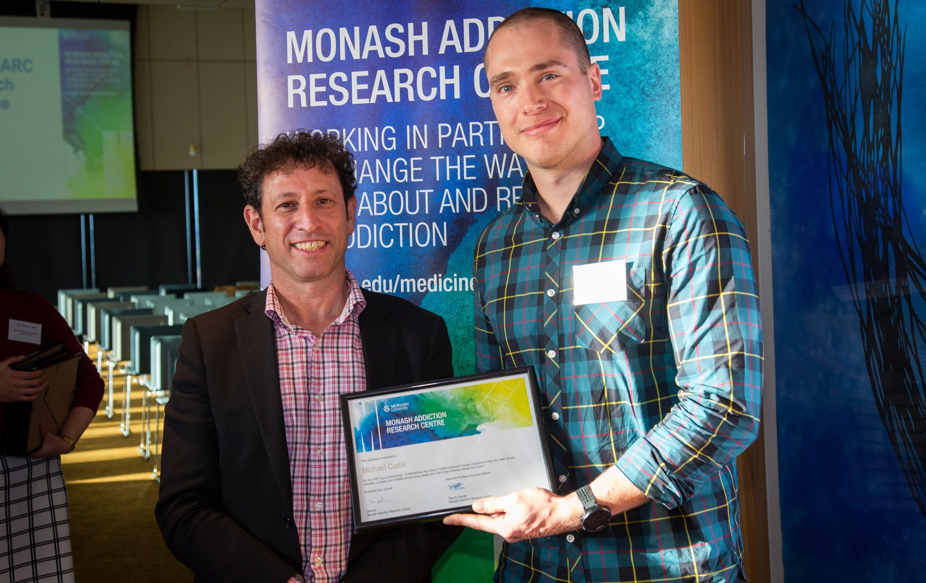 Prof Lubman presenting Dr Curtis with a 2019 MARC PhD Top-up Scholarship