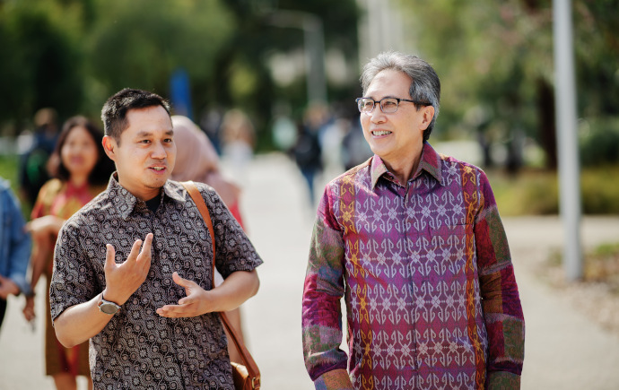 Academic and student walking together