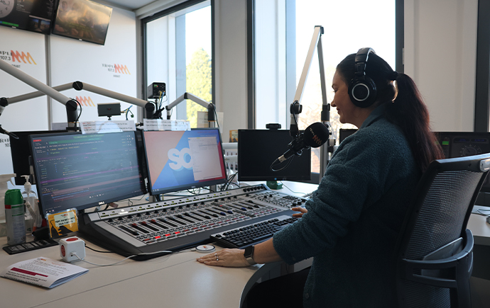 Kaz presenting while sitting at radio presenter desk