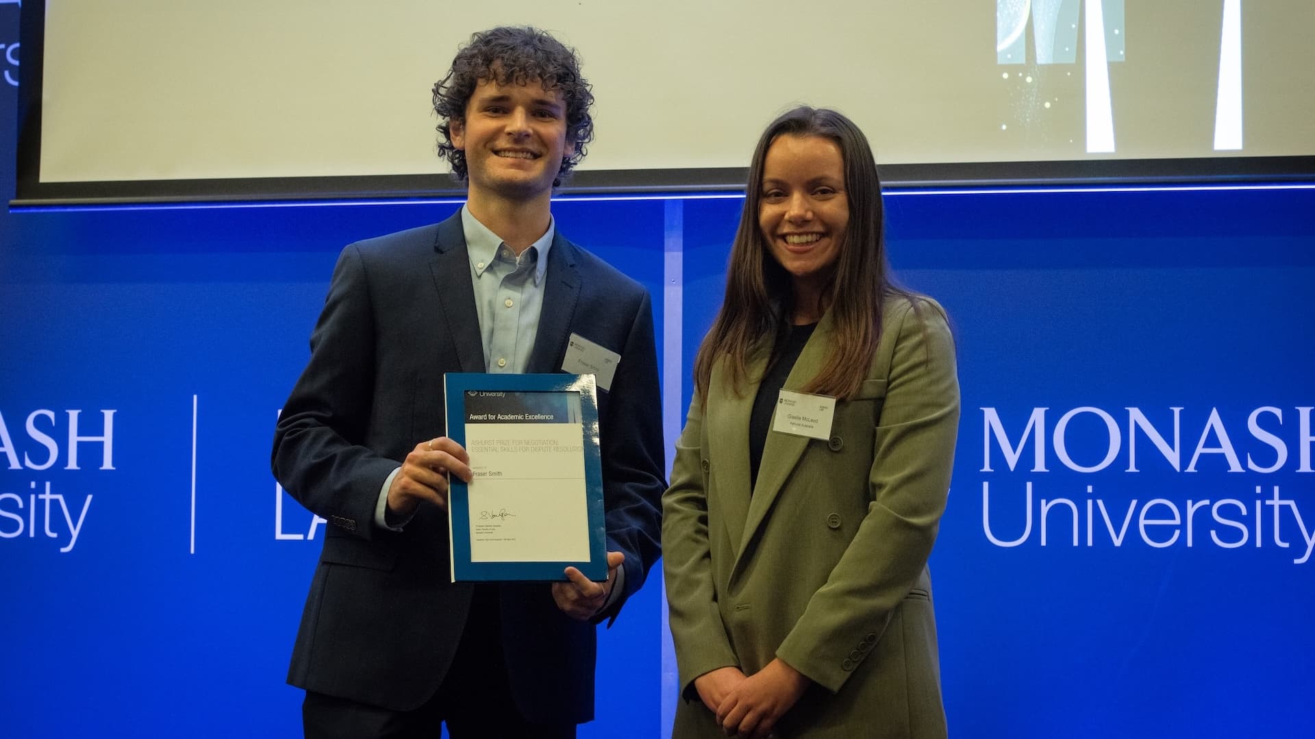 Fraser Smith accepts his prize from Giselle McLeod of Ashurst.