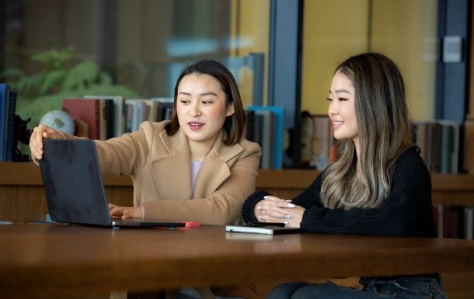 Monash Business School students using a laptop