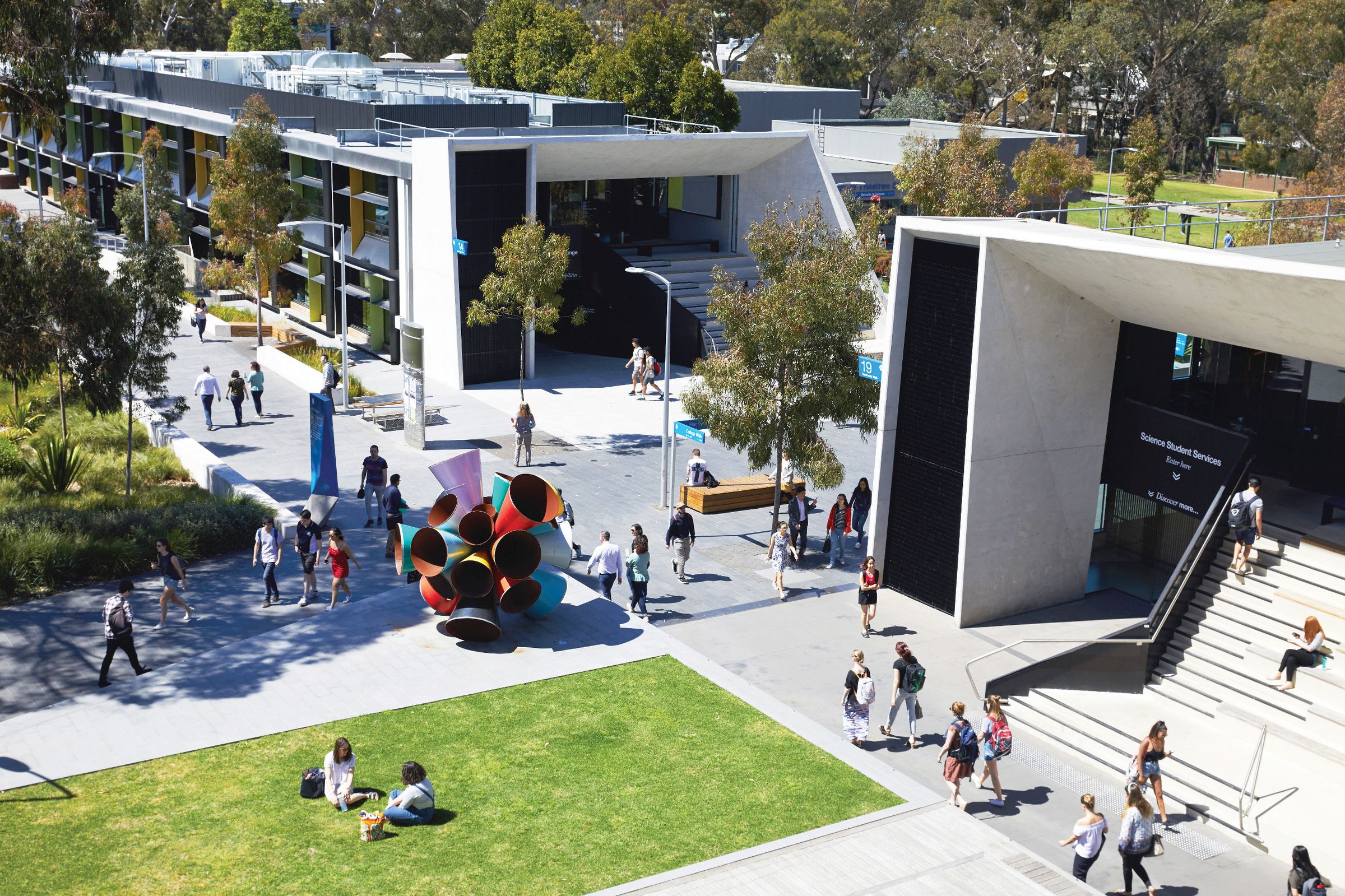 Exterior view of a modern university building surrounded by trees and green lawn at the Monash Science precinct