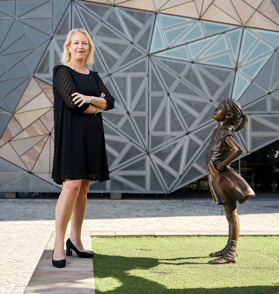 Kimberley Cole standing next to fearless girl bronze statue