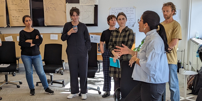 A facilitator leading a workshop. People standing up.