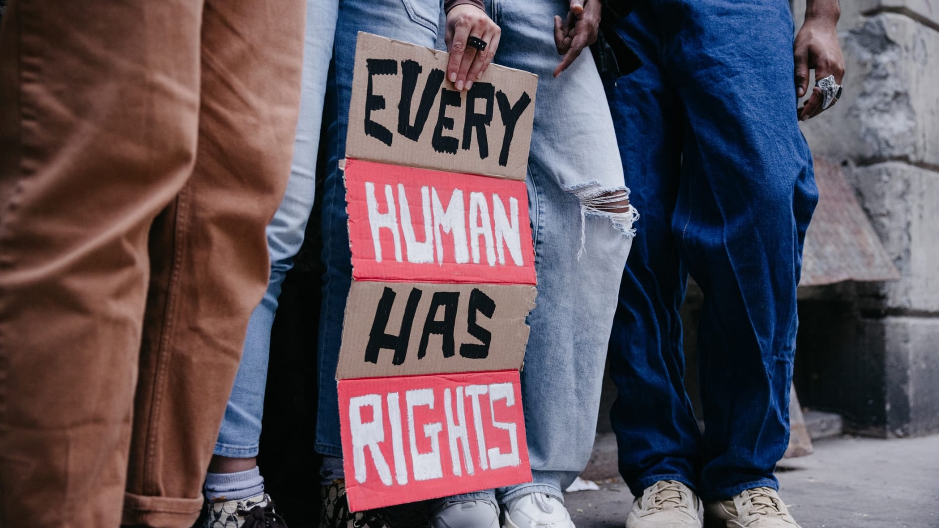People holding sign that reads Every Human Has Rights