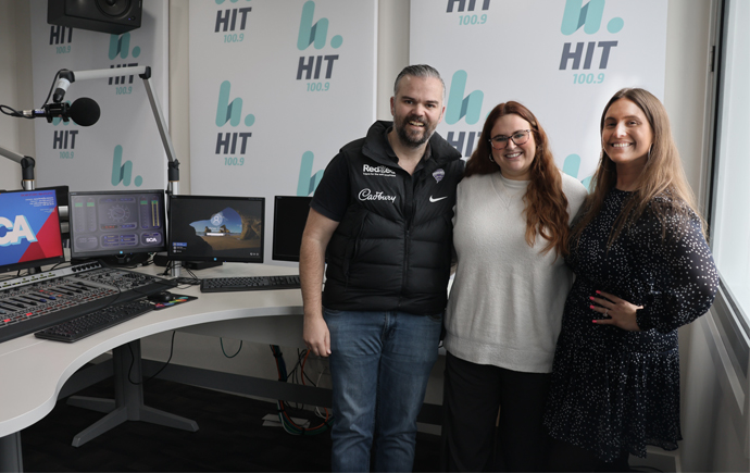 Dan, Zoe, and Christie standing next to radio presenter desk