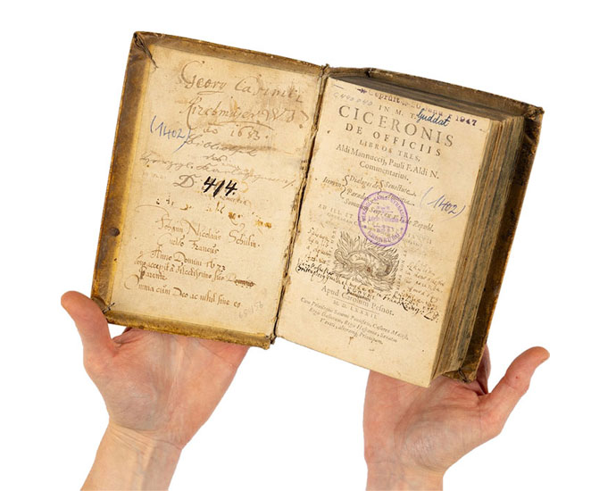 two hands holding a rare book open