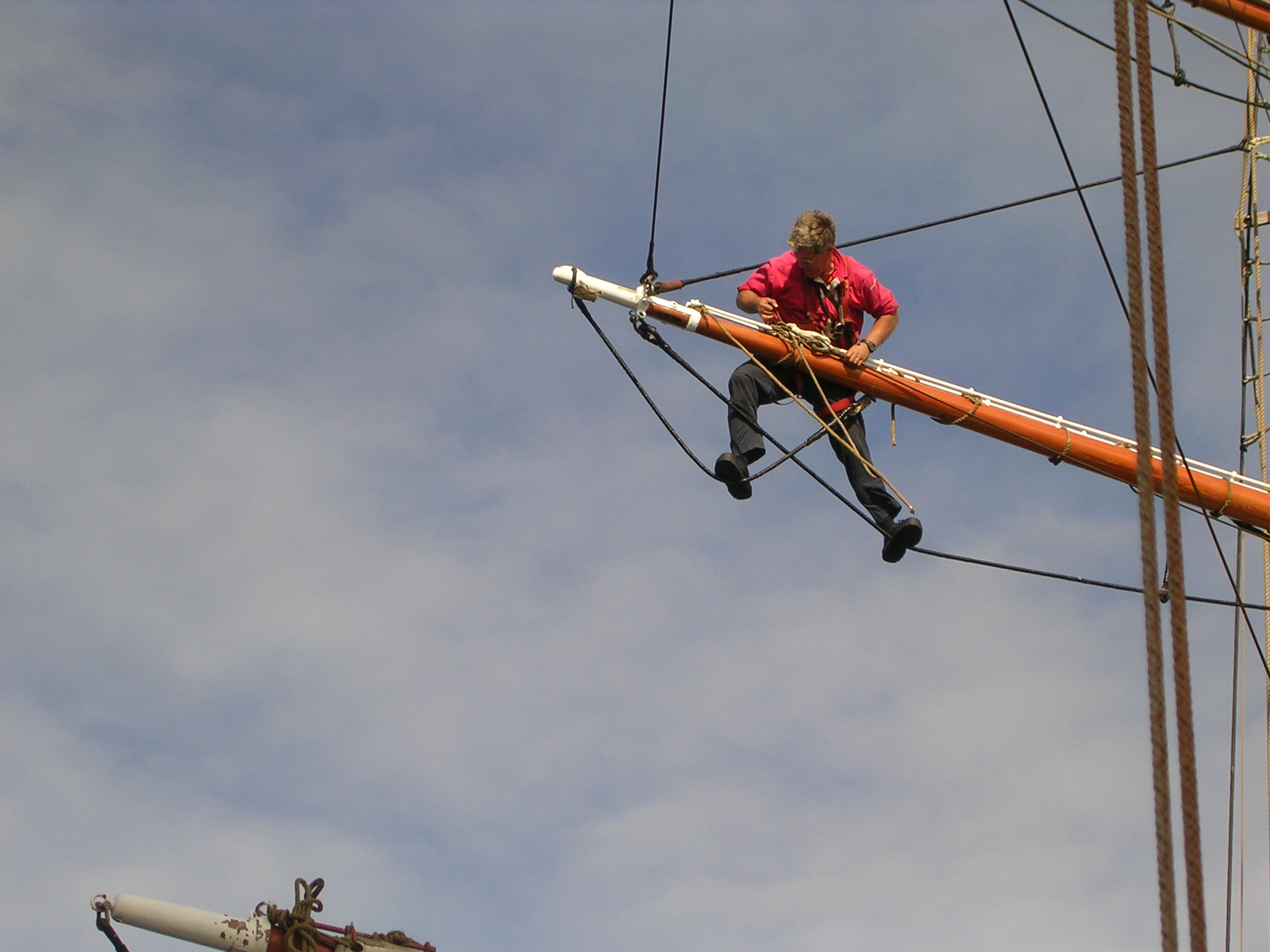 Deckhand standing on main footrope and Flemish horse