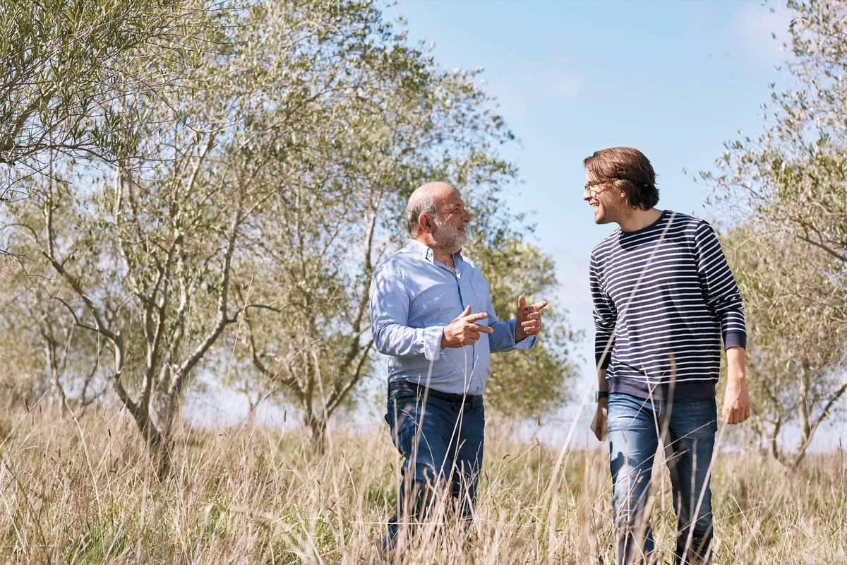 Sandro and his father standing in an olive grove