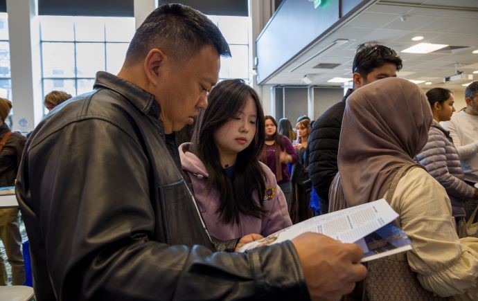 Parent reading a brochure at Open Day