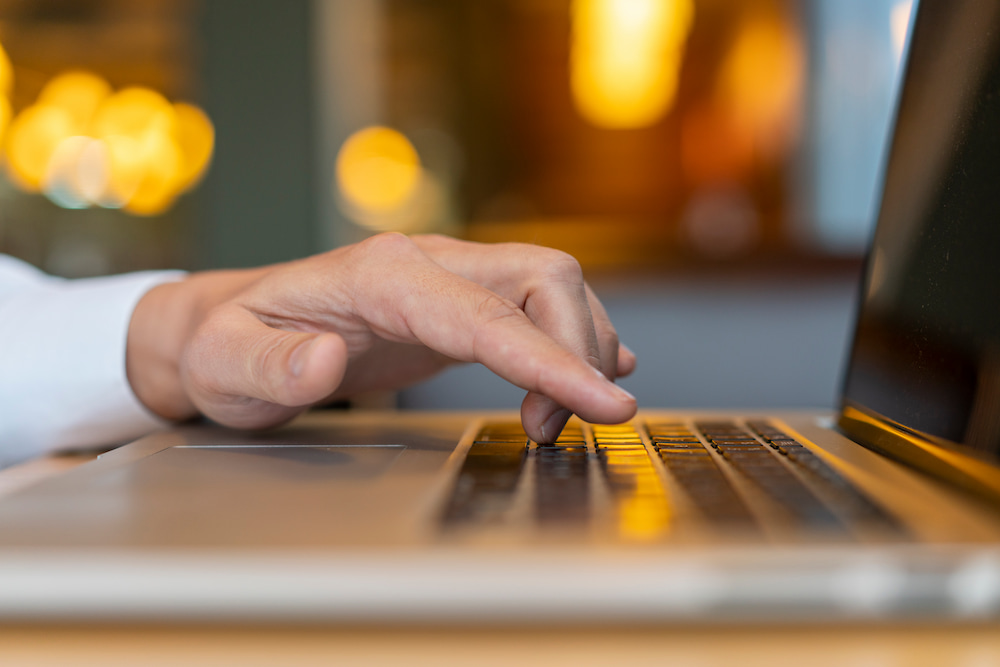 man-typing-laptop-with-bokeh