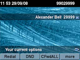 A desk phone screen showing the words ‘Alexander Bell 829999’.