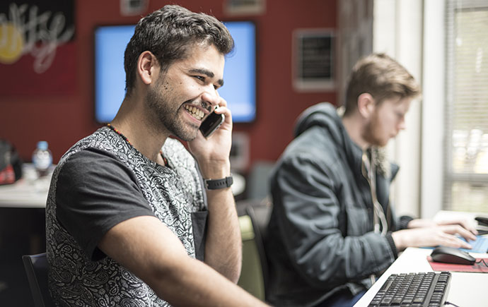 Male student laughing on phone