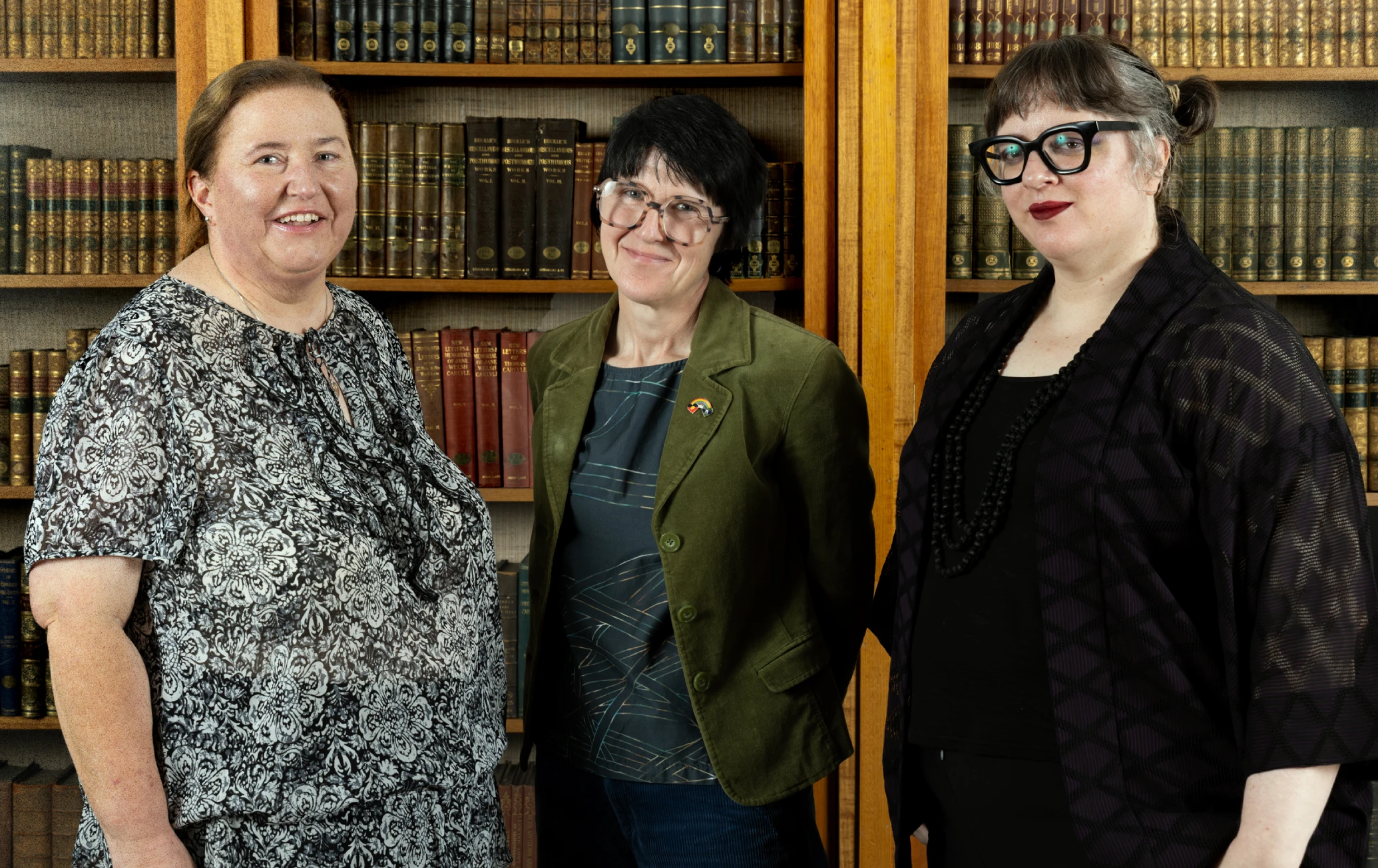 Curators Helen Croaker, Kerri Klump and Anne Holloway standing together in front of a bookshelf