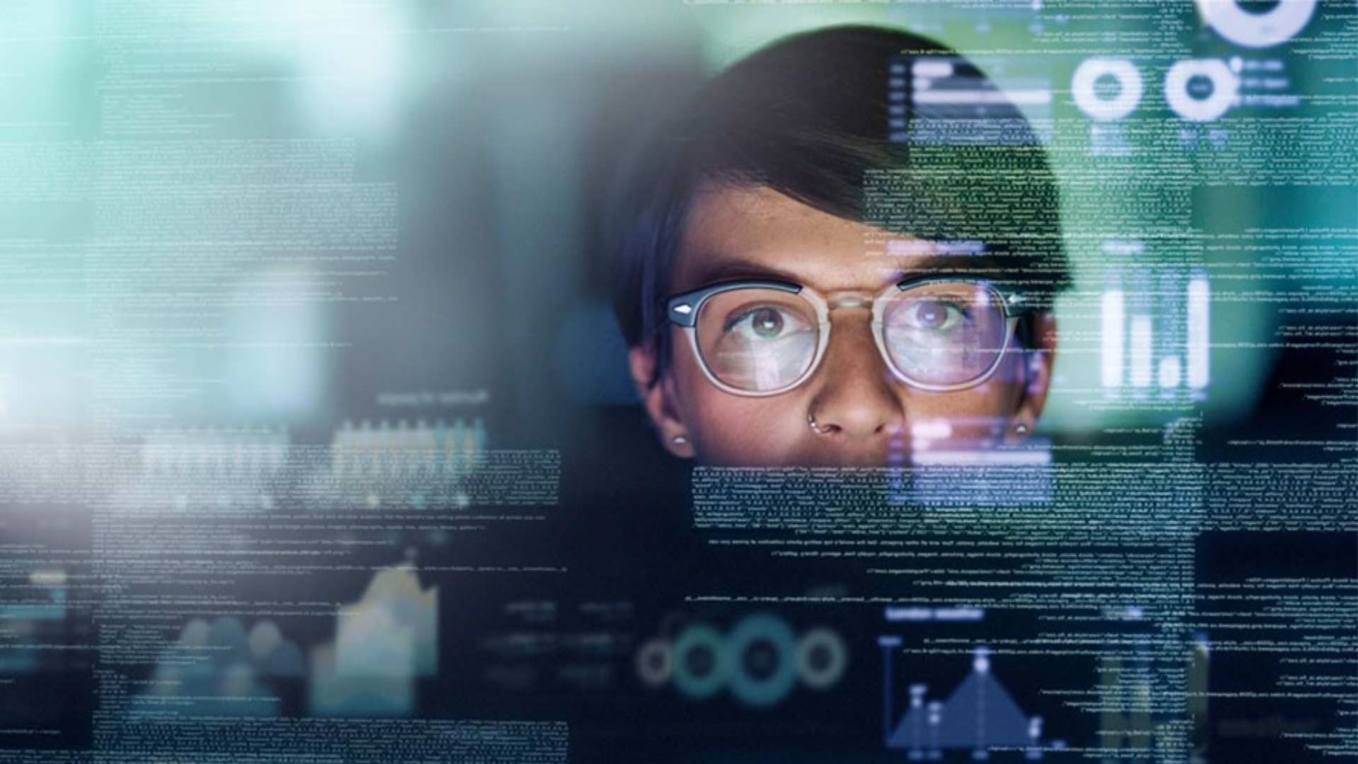 Woman in front of computer screen with code visible